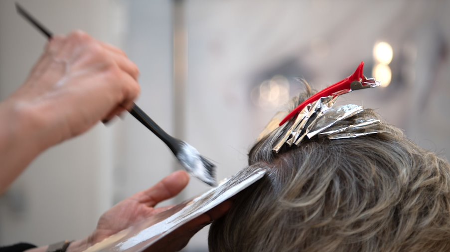 Eine Friseurin färbt einer Kundin mit einem Pinsel die Haare in einem Friseur-Salon. / Foto: Symbolbild Friseur/dpa/Symbolbild