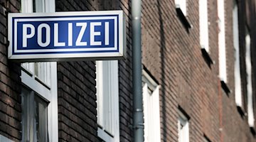 Ein Schild mit der Aufschrift «Polizei» hängt an einem Polizeipräsidium. / Foto: Roland Weihrauch/dpa/Symbolbild