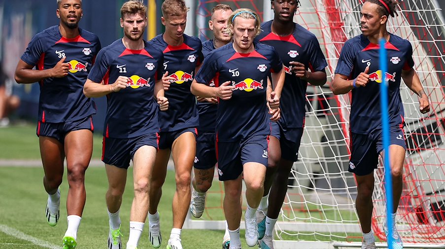 Leipzigs Spieler Benjamin Henrichs (l-r), Timo Werner, Dani Olmo, Xaver Schlager, Emil Forsberg, El Chadaille Bitshiabu und Yussuf Poulsen laufen während einer Trainingseinheit über den Platz. / Foto: Jan Woitas/dpa