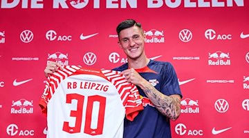 Leipzigs Neuzugang Benjamin Sesko präsentiert sein Trikot. / Foto: Jan Woitas/dpa