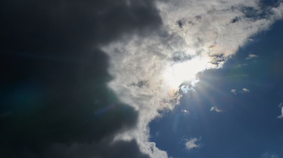 Die Sonne kommt hinter Regenwolken hervor. / Foto: Annette Riedl/dpa/Symbolbild