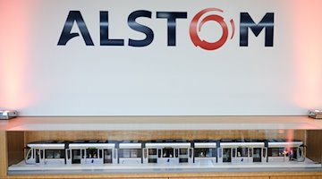 Das Logo von Alstom steht über einer Modelstraßenbahn. / Foto: Annette Riedl/dpa/Archivbild