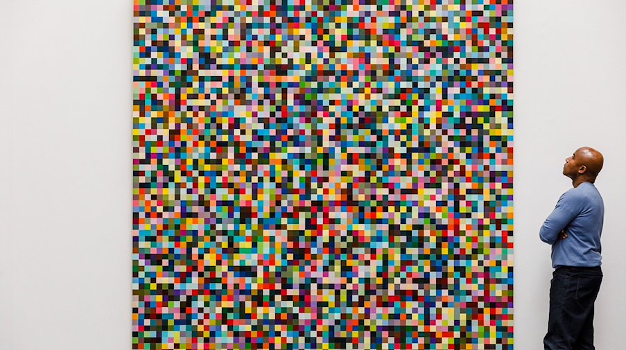 Ein Angestellter des Auktionshaus Sotheby's betrachtet das Gemälde «4096 Farben» des deutschen Künstlers Gerhard Richter. / Foto: Sotheby's/dpa/Archivbild
