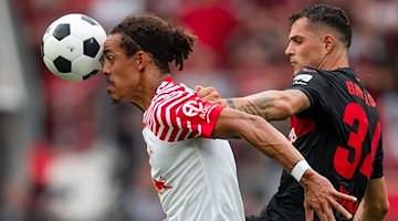 Leverkusens Granit Xhaka (r) und Leipzigs Yussuf Poulsen kämpfen um den Ball. / Foto: Marius Becker/dpa
