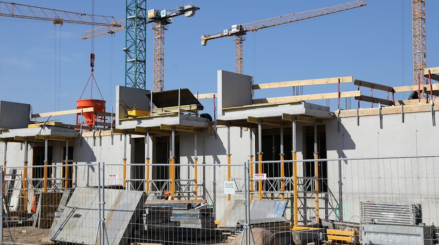 Kräne und Gerüste stehen auf der Baustelle  eines Mehrfamilienhauses. / Foto: Bernd Wüstneck/dpa-Zentralbild/dpa/Symbolbild