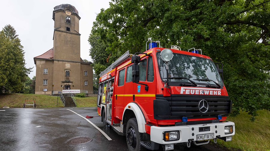 Ein Fahrzeuge der Feuerwehr ist vor der Stadtkirche Großröhrsdorf zu sehen. / Foto: Daniel Schäfer/dpa-Zentralbild/dpa