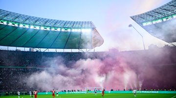 Nebel nach gezündeter Pyrotechnik hängt im Stadion. / Foto: Tom Weller/dpa