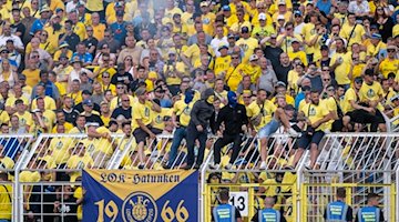 Fans von Lok Leipzig reagieren im Stadion. / Foto: Hendrik Schmidt/dpa