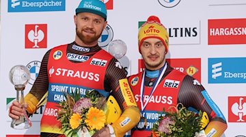 Toni Eggert und Sascha Benecken stehen auf dem Podium bei einer Siegerehrung in Winterberg. / Foto: Friso Gentsch/dpa/Archivbild