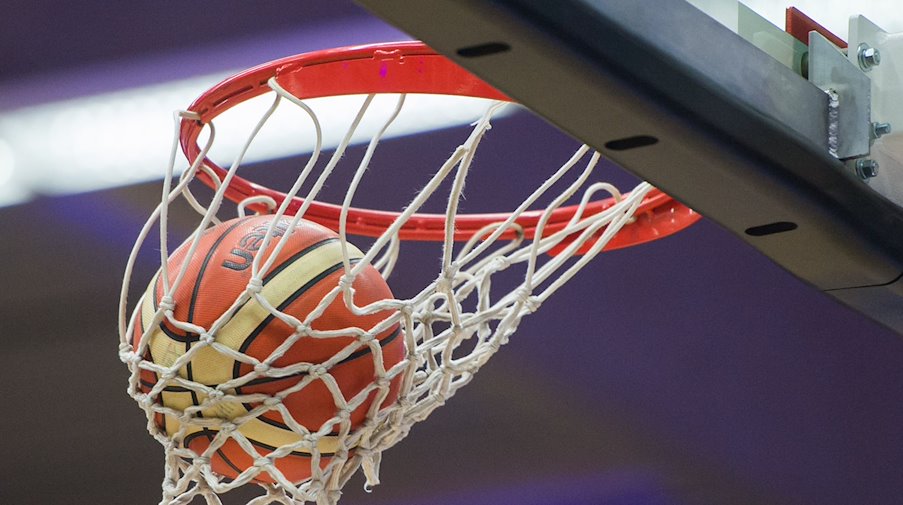 Ein Basketball im Korb. / Foto: Lukas Schulze/dpa/Symbolbild