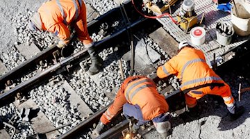 Ein Bautrupp der Bahn repariert auf einer Strecke das Gleisbett. / Foto: Roland Weihrauch/dpa