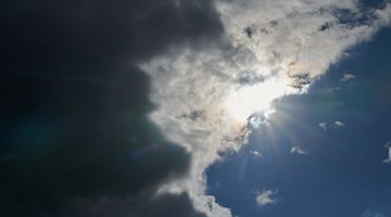 Die Sonne kommt hinter Regenwolken hervor. / Foto: Annette Riedl/dpa/Symbolbild