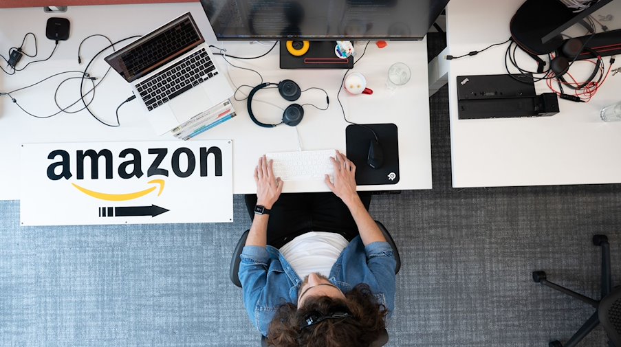 Ein Softwareentwickler von Amazon sitzt am Forschungs- und Entwicklungsstandort an einem Schreibtisch. / Foto: Sebastian Kahnert/dpa