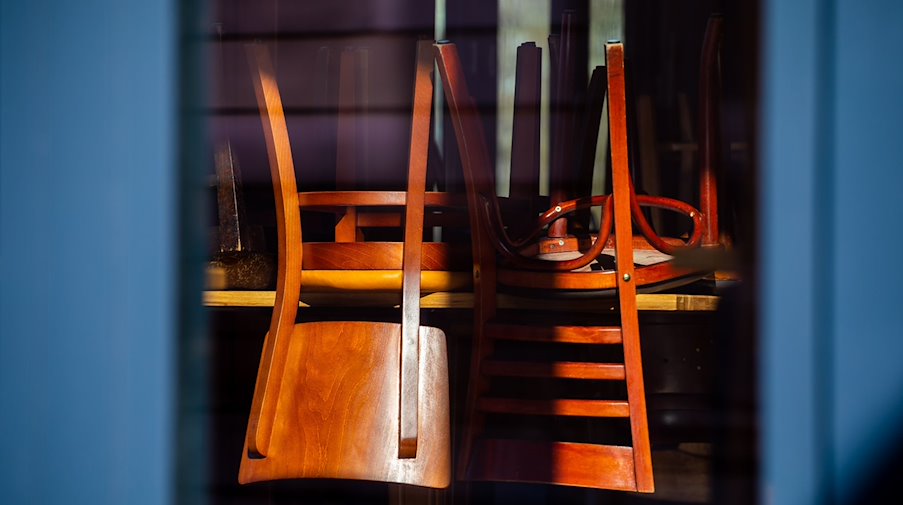 Hochgestellte Stühle sind im einfallenden Sonnenlicht in einem Restaurant in der Altstadt zu sehen. / Foto: Moritz Frankenberg/dpa/Archivbild
