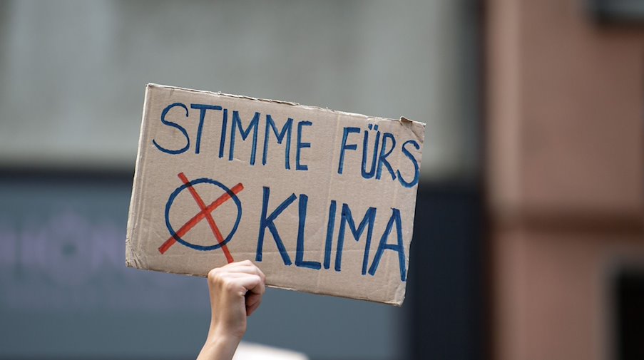 Eine Teilnehmerin hält auf der Fridays for Future-Demonstration ein Protestplakat in den Händen. / Foto: Federico Gambarini/dpa/Symbolbild