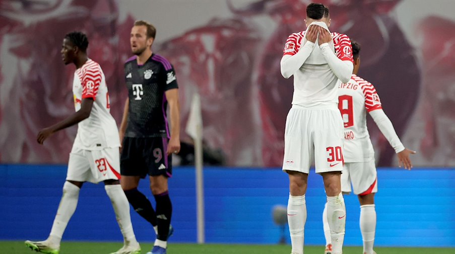 Leipzig's Castello Lukeba (l) and Leipzig's Benjamin Sesko walk off the pitch with Munich's Harry Kane (2nd from left) after the final score was 2-2. / Photo: Jan Woitas/dpa