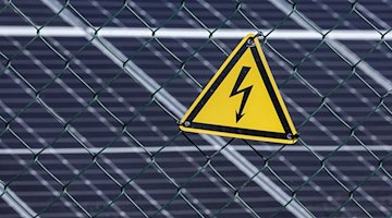 Ein Warnschild warnt vor Starkstrom an der neuen Photovoltaik-Anlage. / Foto: Jan Woitas/dpa