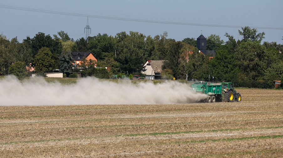 Фермер розкидає вапно на полі для покращення ґрунту / Фото: Jan Woitas/dpa