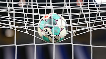 A soccer ball lies in the net before the match / Photo: Friso Gentsch/dpa/Symbolbild