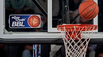 A ball flies toward the basket, which has a logo of the Basketball Bundesliga stuck to it / Photo: Axel Heimken/dpa/Symbolbild