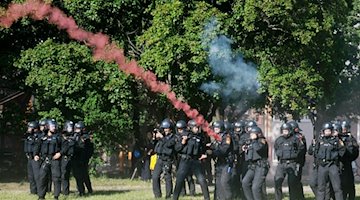 Agentes de policía son lanzados con pirotecnia durante una manifestación de izquierdas. / Foto: Sebastian Willnow/dpa