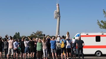 A chimney is blown up in front of onlookers / Photo: Sebastian Willnow/dpa