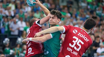 Matej Klima (m), del Leipzig, no logra batir a Max Darj (i), del Berlín, ni a Marko Kopljar / Foto: Jan Woitas/dpa