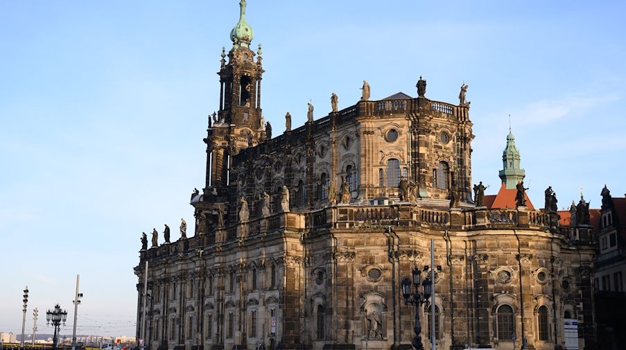 Passanten gehen vor der Dresdner Kathedrale über den Schlossplatz. / Foto: Sebastian Kahnert/dpa-Zentralbild/dpa