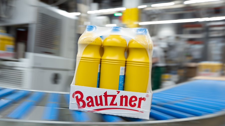 Portionsflaschen mit Bautz'ner Senf rollen an einer Abfüllanlage der Bautz'ner Senf und Feinkost GmbH über ein Förderband. / Foto: Sebastian Kahnert/dpa