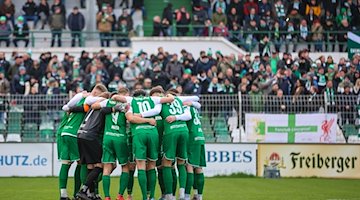 Chemie's players form a circle of players. / Photo: Jan Woitas/dpa