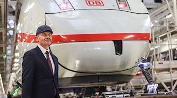 Volker Wissing (FDP), Bundesverkehrsminister, steht vor einem ICE der Deutschen Bahn in der Wartungshalle. / Foto: Oliver Berg/dpa