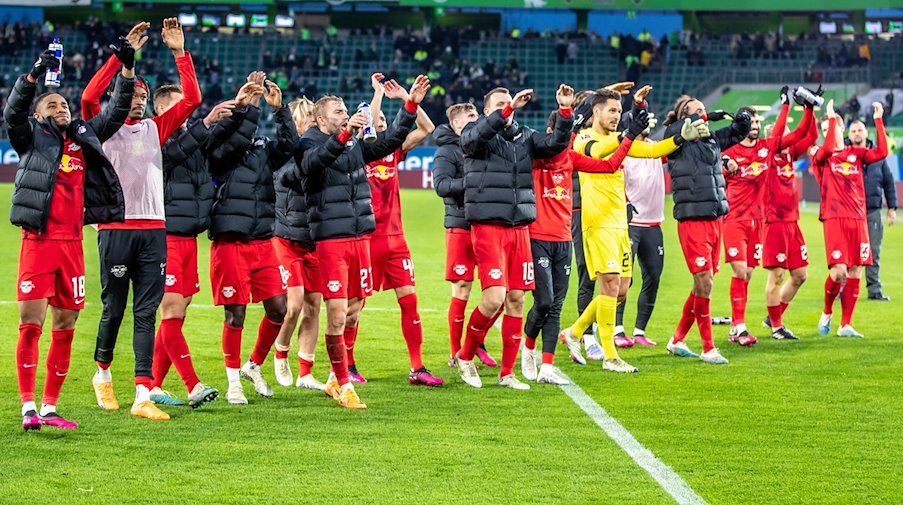 The RB Leipzig team celebrates the victory with their fans. / Photo: Andreas Gora/dpa/Archive