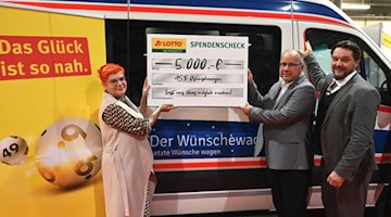 Katrin Koch übergibt ihre Sachsenlotto Möglichmacher-Spende gemeinsam mit Sachsenlotto-Marketingleiter Guido Hannich (rechts) an den Geschäftsführer des ASB, Stefan Mette, für den Wünschewagen.