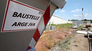 "Baustelle ARGE JVA" steht an einem Baucontainer auf dem Gelände der Baustelle. / Foto: Bodo Schackow/dpa-Zentralbild/dpa