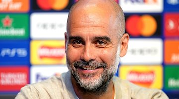 Pep Guardiola, Trainer von Manchester City, lächelt während einer Pressekonferenz. / Foto: Martin Rickett/PA Wire/dpa