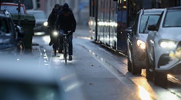 Cyclists are out in the morning rush hour traffic when it rains / Photo: Jan Woitas/dpa