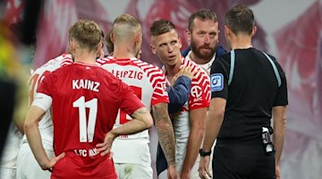 Leipzigs Spieler Dani Olmo (M) muss verletzt vom Platz. / Foto: Jan Woitas/dpa