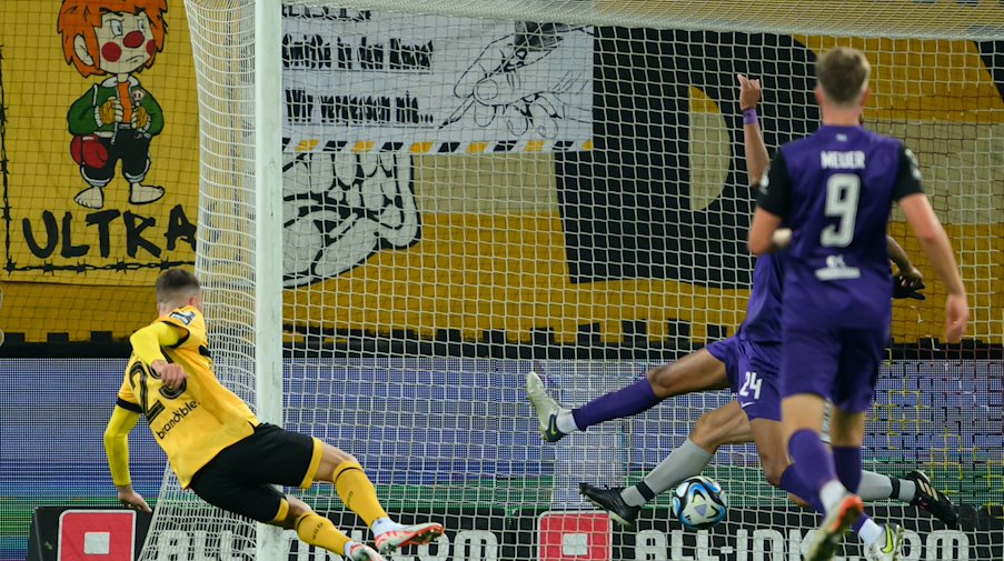 Dynamos Dennis Borkowski (l) erzielt das Tor zum 2:0. / Foto: Robert Michael/dpa