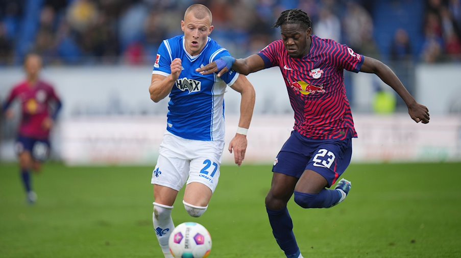 Leipzigs Castello Lukeba(r) und Darmstadts Tim Starke kämpfen um den Ball. / Foto: Thomas Frey/dpa/Archivbild