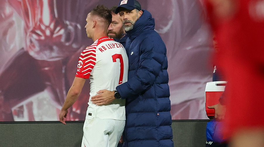 Leipzig coach Marco Rose (r) consoles Dani Olmo, who has to leave the field injured. / Photo: Jan Woitas/dpa