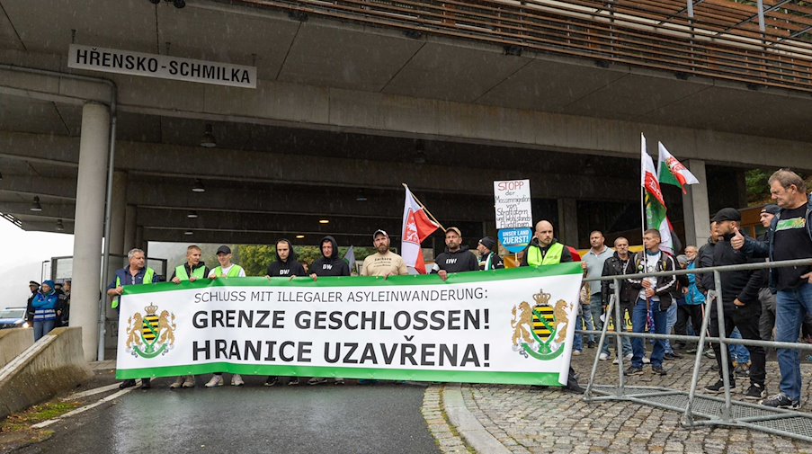 Anhänger der Kleinstpartei Freie Sachsen halten ein Banner mit der Aufschrift "Schluss mit Illegaler Einwanderung Grenze Geschlossen Hranice Uzavřena. / Foto: Daniel Schäfer/dpa