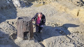 Grabungsleiter Peter Viol dokumentiert einen der beiden bei Grabungen im ehemaligen Tagebau Peres gefundenen Brunnen. / Foto: Jan Woitas/dpa