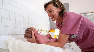 Im Kreißsaal der Muldentalkliniken kümmert sich Mandy Wendrich, Leiterin des freiberuflichen Hebammen-Teams, um ein Neugeborenes. / Foto: Hendrik Schmidt/dpa