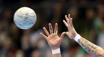 A handball is caught. / Photo: Ronny Hartmann/dpa/iconic image