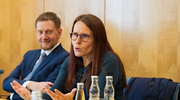 Prof. Langner and Minister President Kretschmer sit next to each other at a meeting table at the launch event for "Schule bewegt Sachsen" in the Saxon State Chancellery. Anke Langner speaks, Michael Kretschmer looks at her from the side and smiles approvingly.