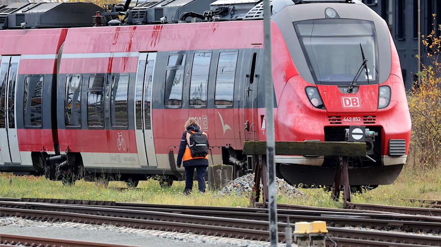 Eine Zugbegleiterin geht in der Nähe des Hauptbahnhofs zu einem abgestellten Zug. / Foto: Bernd Wüstneck/dpa