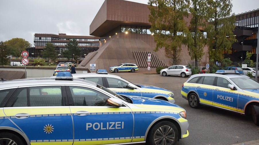 Mehrere Einsatzfahrzeuge der Polizei stehen auf dem Gelände der Hochschule der Bundesagentur für Arbeit. / Foto: Rene Priebe/dpa