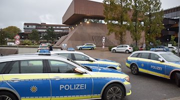 Mehrere Einsatzfahrzeuge der Polizei stehen auf dem Gelände der Hochschule der Bundesagentur für Arbeit. / Foto: Rene Priebe/dpa