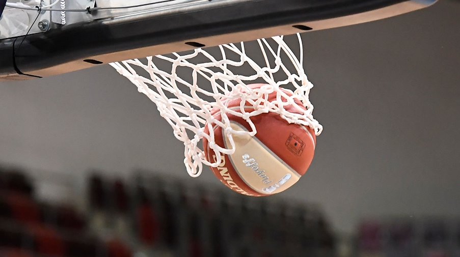 A basketball lands in the hoop / Photo: Thomas Kienzle/dpa/Symbolic image