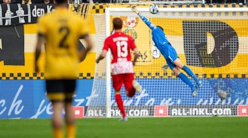 Freiburg goalkeeper Benjamin Uphoff cannot prevent Dynamo's Luca Herrmann from scoring to make it 1:0. / Photo: Robert Michael/dpa